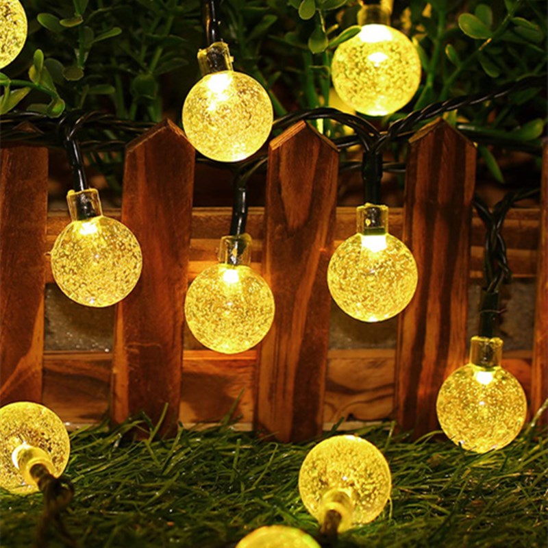 Warm white globe lights above outdoor dining area